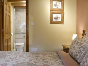 a bedroom with a bed and a toilet at Old Barn Cottage in Lockton +2 photos