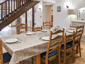a dining room with a long table with glasses on it at Yr Hafod in Trefriw +15 photos