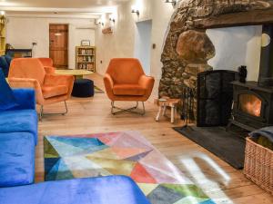 a living room with chairs and a stone fireplace at Yr Hafod in Trefriw