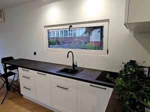 a kitchen with a sink and a window at Apartament Contandair in Olsztyn