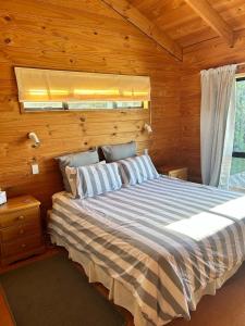 une chambre avec un lit dans une pièce en bois dans l'établissement Bella Vista on the Beach, à Matarangi 10 autres photos