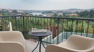 a balcony with a table and chairs and a view at RIVER VIEW TMB oporto station house in Porto
