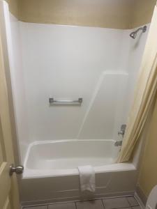 a bathroom with a bath tub with a shower curtain at Somatel Goodlettsville in Goodlettsville +19 photos