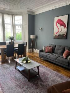 a living room with a gray couch and a table at 3BR Apt Near Ibrox Subway Sleeps 7 and Parking in Glasgow