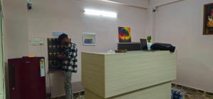 a man standing at a counter in a room at Hotel O Sea Coastal in Kākināda