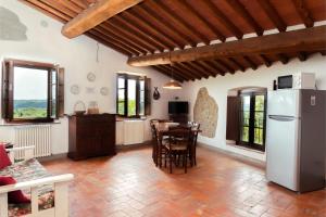 eine Küche und ein Esszimmer mit Kühlschrank und Tisch in der Unterkunft Große Ferienwohnung in Rapale mit Terrasse, Grill und gemeinsamem Pool in Rapale