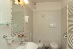 ein Badezimmer mit Waschbecken, Toilette und Spiegel in der Unterkunft Große Ferienwohnung in Rapale mit Terrasse, Grill und gemeinsamem Pool in Rapale