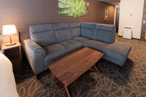 a living room with a blue couch and a coffee table at Hotel Silk Tree Nagoya in Nagoya