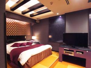 a bedroom with a bed and a flat screen tv at ホテルキャットハウス門真店 in Osaka +17 photos