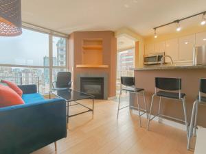 Una sala de estar con un sofá azul y una cocina. en DT Condo Nice View 2 BDR & Bath at Robson Square, en Vancouver