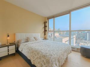 Un dormitorio con una cama y una ventana grande. en DT Condo Nice View 2 BDR & Bath at Robson Square, en Vancouver
