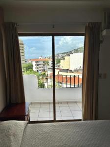 een slaapkamer met een bed en een groot raam bij Departmento Ballena in Puerto Vallarta