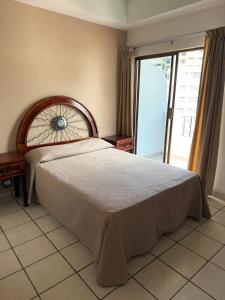 een slaapkamer met een groot bed en een groot raam bij Departmento Ballena in Puerto Vallarta +19 foto's