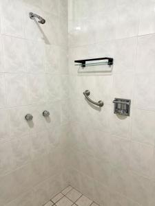 een badkamer met een douche met witte tegels bij Departmento Ballena in Puerto Vallarta