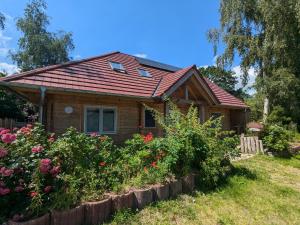 a small house with flowers in front of it at Borner Holzhaus in Born