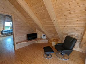 a room with a chair and a television in a cabin at Borner Holzhaus in Born