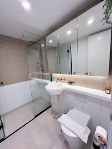 Un baño con inodoro, lavabo y ducha. en Melbourne's Premium on Spencer, en Melbourne 17 fotos más