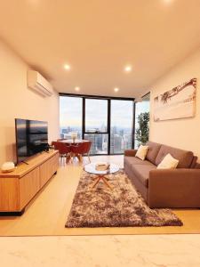 Una sala de estar con un sofá, un televisor y una mesa. en Melbourne's Premium on Spencer, en Melbourne