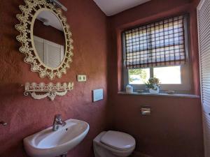 a bathroom with a sink and a toilet and a mirror at Haus Stoeckwiese in Wieck +7 photos