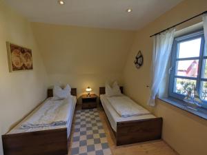 two beds in a room with a window at Haus Stoeckwiese in Wieck