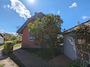 a small red house with a white garage at Haus Stoeckwiese in Wieck