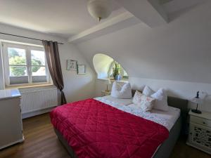 ein Schlafzimmer mit einem roten Bett mit einer roten Decke in der Unterkunft Haus Sonne in Born