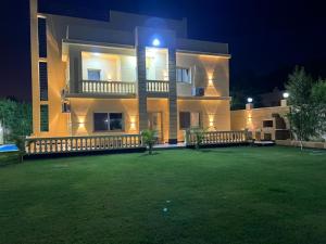 ein großes Gebäude mit einer Wiese davor bei Nacht in der Unterkunft الاسكندريه كينج مريوط in King Mariout