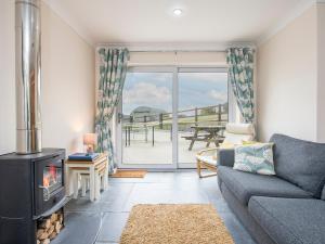 a living room with a couch and a fireplace at Golwg Y Cwm in West Cilrhedyn