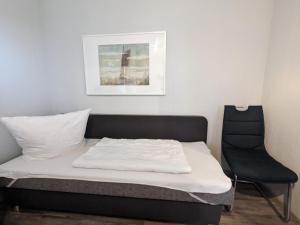a bed and a chair in a room at Nussbaum in Wieck