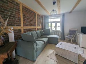 a living room with a couch and a brick wall at Eichenlund in Born