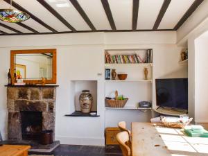 ein Wohnzimmer mit Kamin und Tisch in der Unterkunft Nessa Cottage - Uk47087 in Davidstow