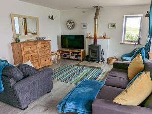 a living room with two couches and a television at The Beach House in Dunvegan