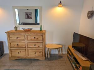 a living room with a dresser and a mirror at The Beach House in Dunvegan