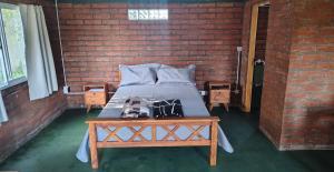 a bedroom with a bed and a brick wall at OKIN 1 Cobos in Mar de Cobo