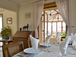 a dining room with a table with chairs and a window at Rowan Cottage in Aviemore