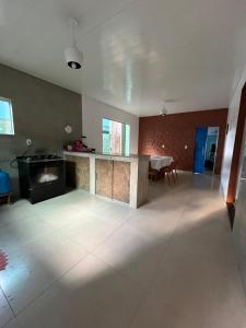 an empty living room with a fireplace and a table at Casa no Aspha Ville em Ananindeua in Ananindeua