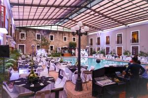 a restaurant with tables and chairs and a pool at Hotel San Francisco Tlaxcala in Tlaxcala de Xicohténcatl