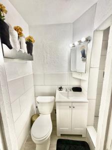 a white bathroom with a toilet and a sink at # 11 Cozy Mini House by the Lake 