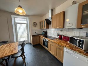a kitchen with wooden cabinets and a table with chairs at Maison 4 chambres, 2 étoiles, près plage, port de pêche – Les Sables-d'Olonne - FR-1-197-605 in Les Sables-dʼOlonne