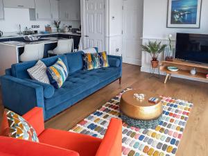 Una sala de estar con un sofá azul y una mesa. en Zero Degrees North, en Sheringham