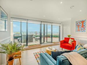 sala de estar con sofá azul y silla roja en Zero Degrees North, en Sheringham