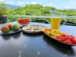 ein Tisch mit Obsttellern und einem Glas Orangensaft in der Unterkunft Luxury 2BR Bolongo Ocean View Private Beach in Higuera Blanca