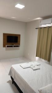 a hospital room with a bed and a flat screen tv at Pousada Tangará 