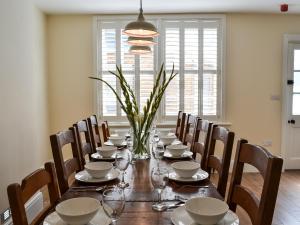 a dining room table with chairs and a long table with plates and glasses at Princess Lodge in Scarborough