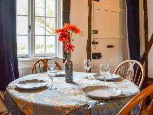 a table with glasses and a vase with flowers on it at The Cottage At Harple Farm in Detling +22 photos