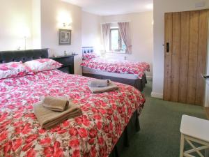 a hotel room with two beds with towels on them at Two Bridge Cottage in Winsham