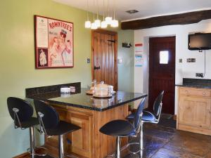 a kitchen with a bar with chairs around it at The Landings Cottage in Nun Monkton