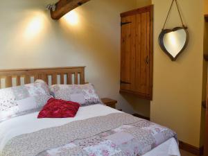 a bedroom with a bed with a heart mirror on the wall at The Landings Cottage in Nun Monkton