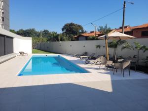 a swimming pool with chairs and an umbrella at insignia5 in Luque