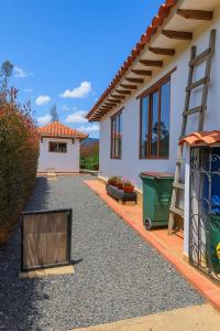 a house with a gravel driveway and a ladder at Cabaña familiar con 4 dormitorios y baños privados in Villa de Leyva